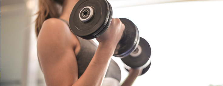 Woman holding 2 dumbbells strength training